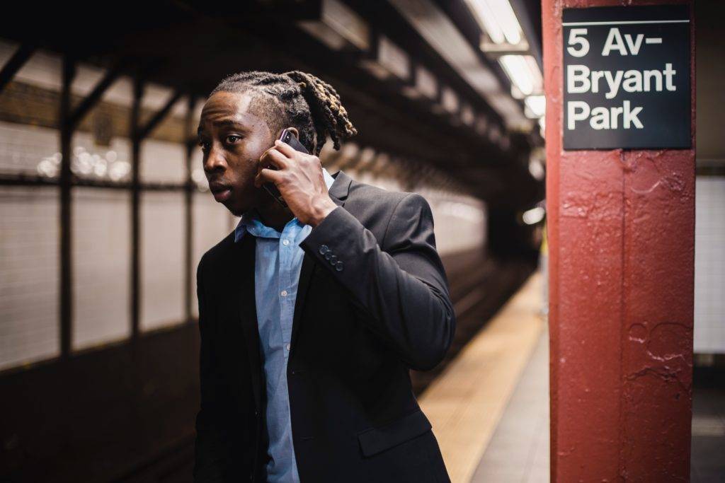 What is WiFi calling? How do you enable it on iPhone & Android? Man making a call in the subway.