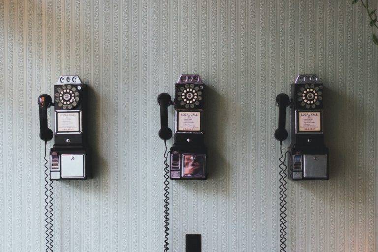a row of three landline telephones next to each other