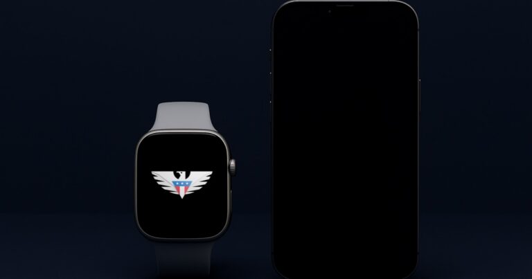 A smartwatch with the us mobile eagle on its screen placed beside a phone with a dark screen